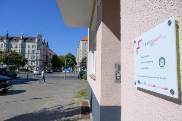 Das Bild zeigt das Hausschild von Frauenzukunft und den Blick auf die Straße daneben.